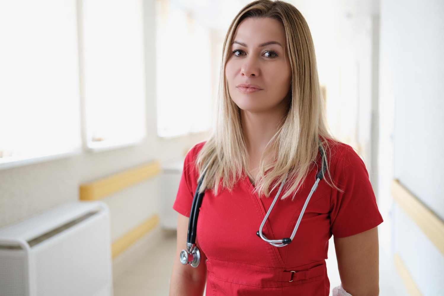 A young female doctor wearing doctor apron and standing at hospital.